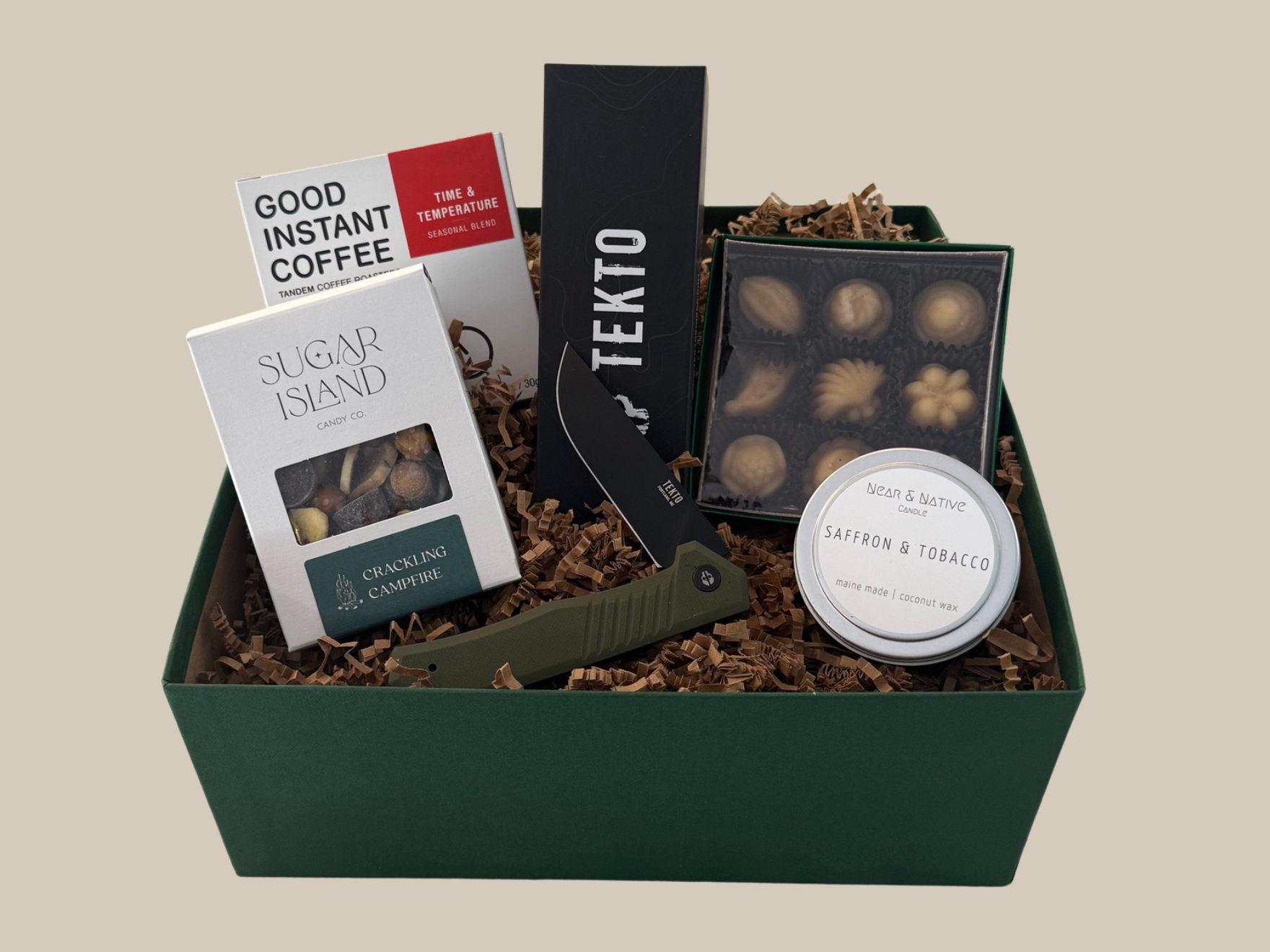 Gift basket with various items including coffee, chocolate, and a knife on a beige background