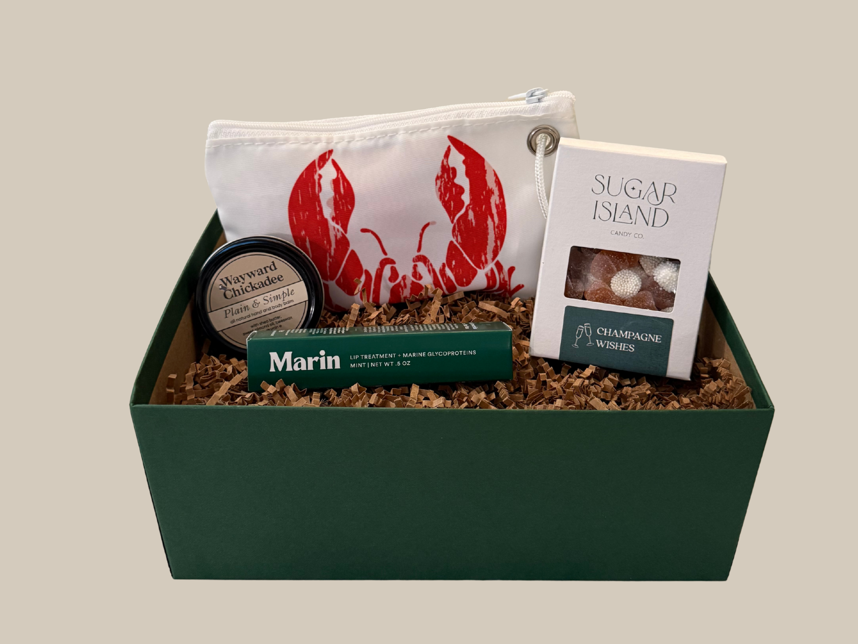 Gift basket with a pouch, book, and other items on a neutral background